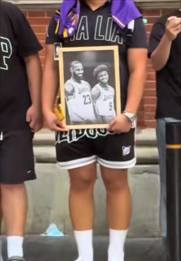 球迷手持詹姆斯和布朗尼的黑白画框合照在外滩等待